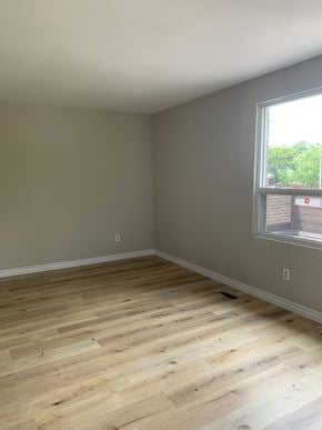 Oakville apartment for rent - an empty room with wooden floors and a window