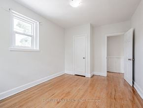 Toronto apartment for rent - a bedroom with white walls and wood flooring and a window