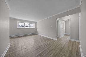 Ottawa apartment for rent - A room with wooden flooring and a window showing a snowy landscape outside.