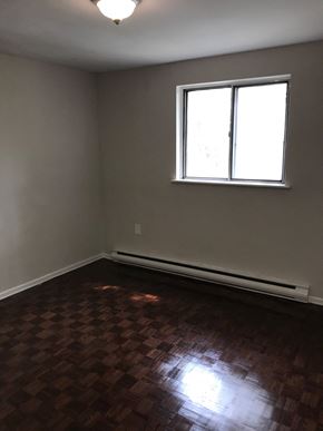 Toronto apartment for rent - an empty room with wooden floors and a window