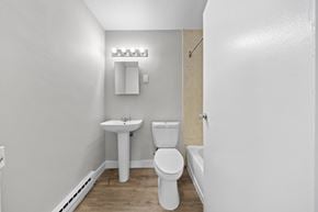 Ottawa apartment for rent - A white toilet sits next to a sink in a small bathroom.