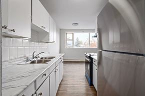 Collingwood apartment for rent - a kitchen with white cabinets and stainless steel appliances and a window