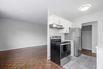 Collingwood apartment for rent - A kitchen with a black stove top oven and a refrigerator.