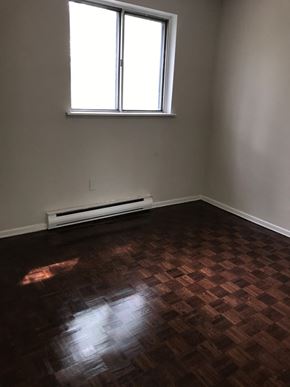Toronto apartment for rent - an empty room with wooden floors and a window