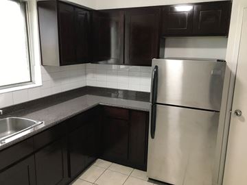 Toronto apartment for rent - a kitchen with black cabinets and a stainless steel refrigerator