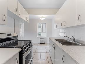 Toronto apartment for rent - a kitchen with white cabinets and a sink and a stove