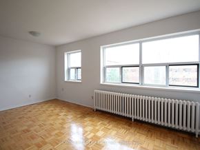 Burlington apartment for rent - the living room of a house with a wood floor and a radiator and large windows