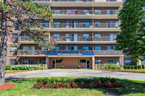 Toronto apartment for rent - an apartment building with a lawn and flowers in front of it