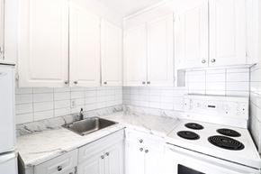Toronto apartment for rent - a white kitchen with marble counter tops and white cabinets