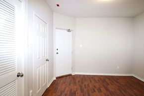 Toronto apartment for rent - a bedroom with white walls and wood floors and a white door