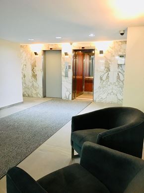 Toronto apartment for rent - a seating area in the lobby of an office building with two chairs