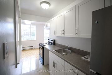 Toronto apartment for rent - an empty kitchen with white cabinets and a sink