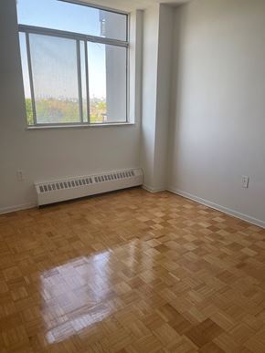 Toronto apartment for rent - an empty room with a wooden floor and a large window