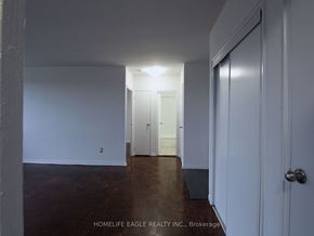 Toronto apartment for rent - a bedroom with white walls and wood floors and a closet
