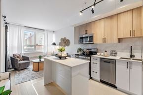 Ottawa apartment for rent - A modern kitchen with white cabinets and a large island.