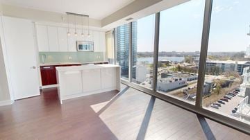 Ottawa condo for rent - A large open space with a kitchen area and a view of the city.