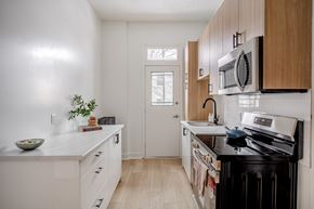 Ottawa apartment for rent - A kitchen with white cabinets and a black stove top.