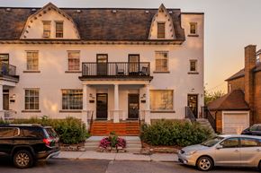 Ottawa apartment for rent - A white house with a black car parked in front.