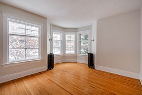 Ottawa apartment for rent - A room with a wooden floor and two windows.