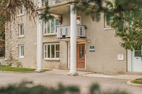 Aylmer apartment for rent - A building with a balcony and a brown door.