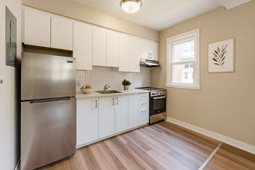 Ottawa apartment for rent - A kitchen with a stainless steel refrigerator and white cabinets.