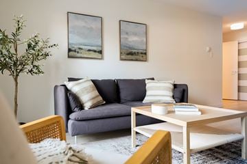 Ottawa apartment for rent - A living room with a grey couch, a coffee table, and two landscape paintings on the wall.