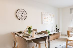 Ottawa apartment for rent - A dining room with a table set for two and a clock on the wall.