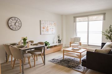 Ottawa apartment for rent - A living room with a dining table set for two and a couch.