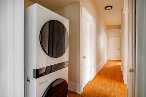 Ottawa apartment for rent - A white LG washing machine is in a narrow hallway.