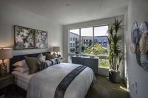 San Diego apartment for rent - A bedroom with a large bed and a view of the city at Purl Apartments, San Diego, CA