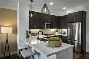 San Diego apartment for rent - A modern kitchen with a white countertop and stainless steel appliances at Purl Apartments, San Diego, CA
