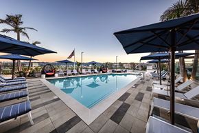 San Diego apartment for rent - A pool surrounded by lounge chairs and umbrellas.