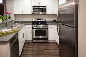 San Diego apartment for rent - A modern kitchen with a stainless steel refrigerator, oven, and microwave. at Circa 37 Apartments, San Diego, California