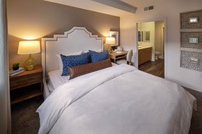San Diego apartment for rent - A bedroom with a large bed and a nightstand with a lamp at West Park Apartments, California