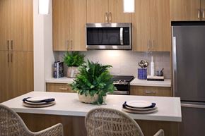 Oceanside apartment for rent - a kitchen with a counter and a table with chairs at Luma at El Corazon Apartments, Oceanside, CA 92056