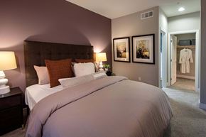 San Diego apartment for rent - A bedroom with a large bed and a white robe hanging on the door at Circa 37 Apartments, San Diego, California