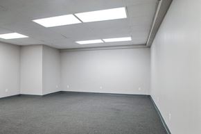 Philadelphia apartment for rent - A large empty room with carpeted floor and fluorescent lights on the ceiling.