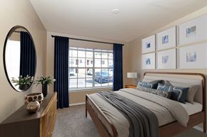 Nashville apartment for rent - A bedroom with a large bed and a window with blue curtains.
