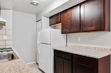 Philadelphia apartment for rent - A kitchen with a white refrigerator and brown cabinets.