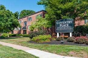 Magnolia apartment for rent - A brick building with a sign that says Coventry Place Apartments.