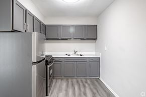 Magnolia apartment for rent - A kitchen with a refrigerator, sink, and cabinets.