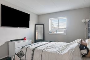 Philadelphia apartment for rent - A bedroom with a bed, a dresser, a mirror, and a television.
