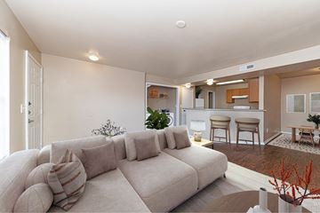Nashville apartment for rent - A living room with a large couch and a dining area in the background.