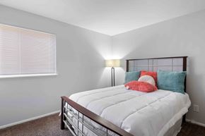 Woodlawn apartment for rent - A bedroom with a white bed and a window with blinds.