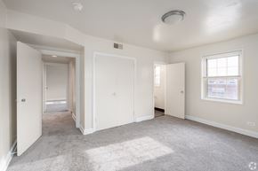 Baltimore apartment for rent - A spacious, empty room with white walls and carpeted floor.