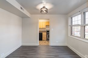 Baltimore apartment for rent - A spacious, empty room with a kitchen in the background.