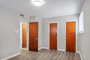 Philadelphia apartment for rent - Three wooden doors in a room with light grey walls.