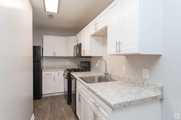 Greensboro apartment for rent - a kitchen with white cabinets and granite counter tops and