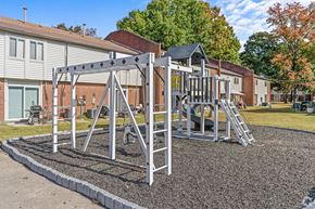 Norfolk apartment for rent - a playground with a swing set in front of a house