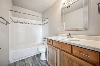 A bathroom with a toilet sink and shower and a mirror